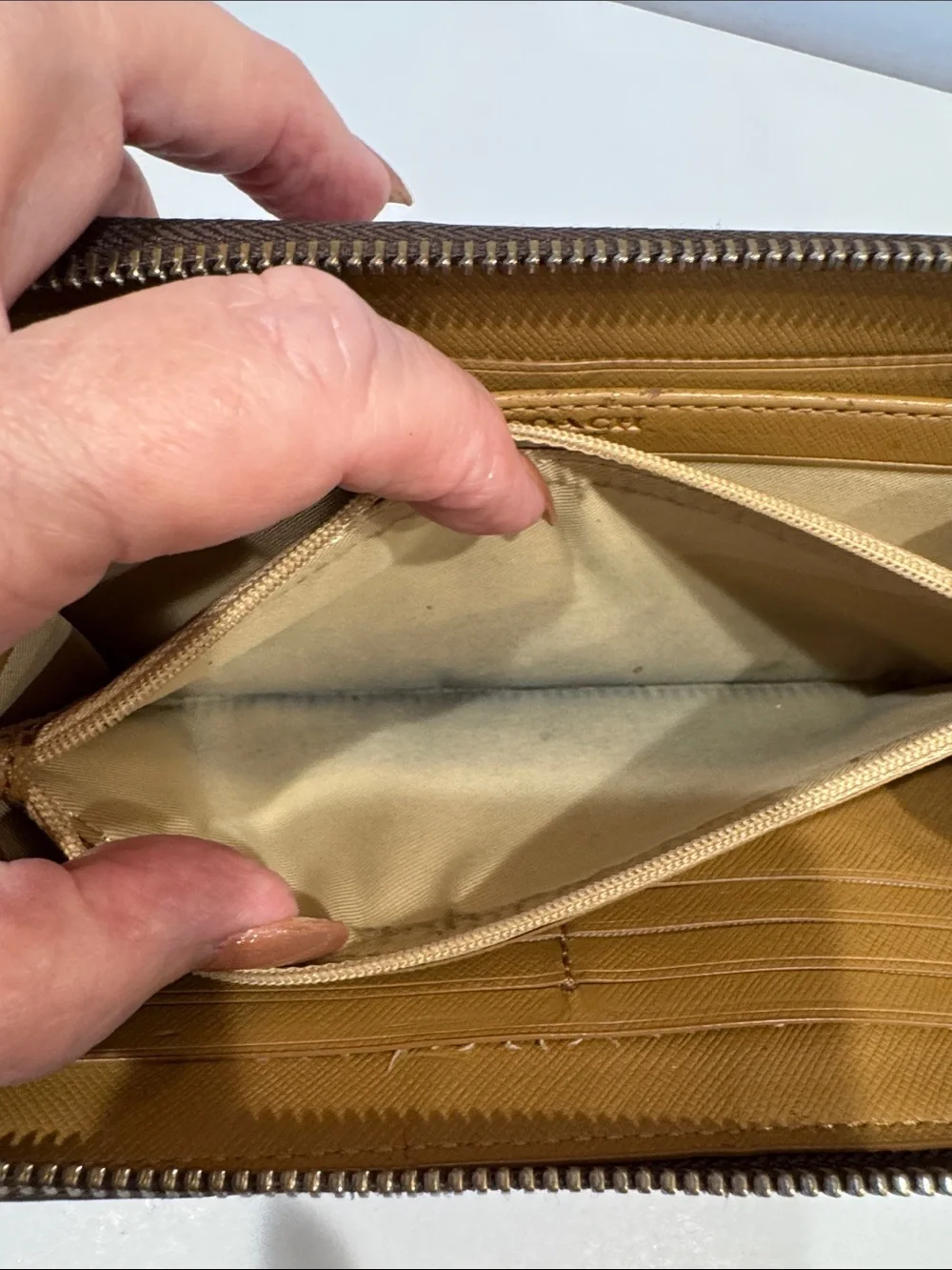 Coach Brown/Tan Signature Zip Wallet with Logo Plaque tags inside.